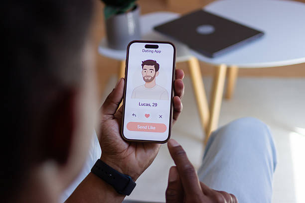 istock Young man using dating app on smartphone at home 2218107617