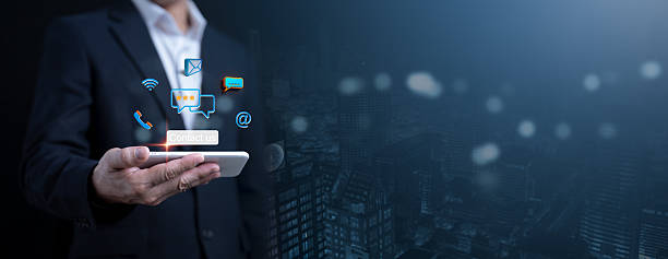 istock Digital connectivity and communication concept with a businessman holding a smartphone, surrounded by glowing icons for messaging, email, call, and social media. 2218108580