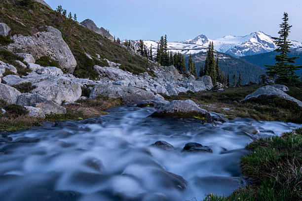 View past mountain stream and mountains in alpenglow, Whistler, British Columbia
