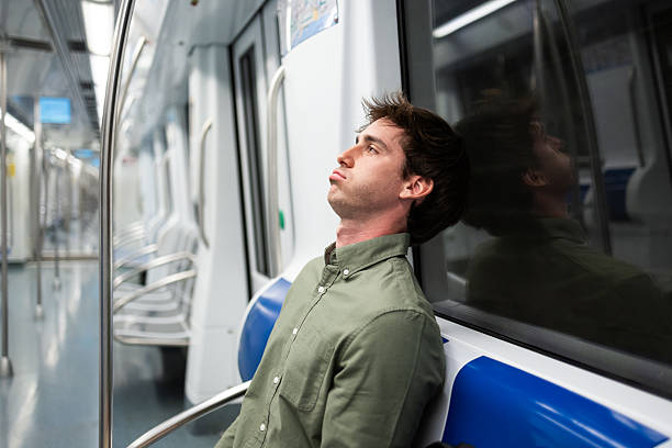 istock Tired businessman relaxing on subway seat during commute 2218118277