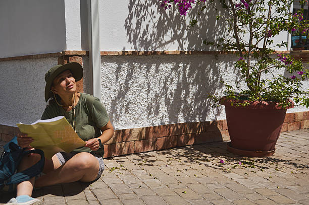 istock Traveler Relaxing with a Map by a Mediterranean Village Wall 2218119703