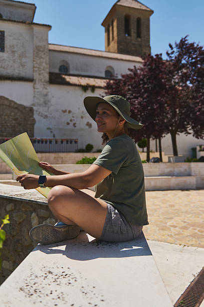 istock Traveler Exploring a Scenic Medieval Village With Map and Sun Hat 2218119818