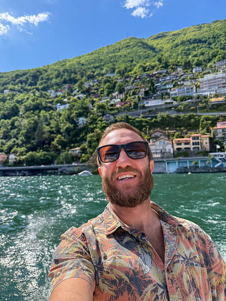 istock Man Smiling on Boat with Scenic Lake and Mountain View 2218120311