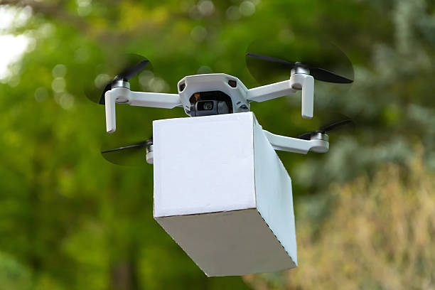 istock Quadcopter with a box in the air: drone with rotating propellers carries cargo, parcel delivery in nature. Safe and environmentally friendly logistics. 2218122751