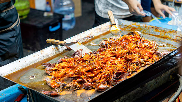 istock The seller cooks grilled squid for customers who are queuing. 2218122977