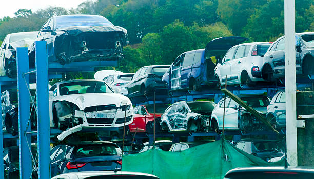 Scrapping , car dismantling. Wrecked car junkyard, forest in the background, environmental issues. Galicia, Spain.