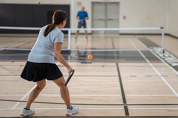 Two Players Competing in an Indoor Pickleball Match on a Gym Court stock photo