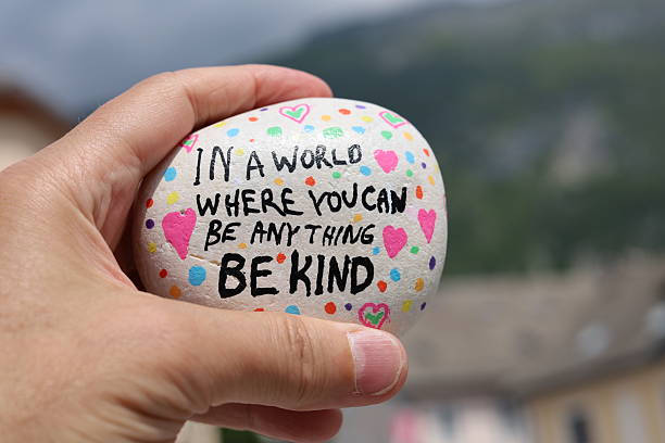 istock In a world where you can be anything be kind painted stone held in hand 2218126869