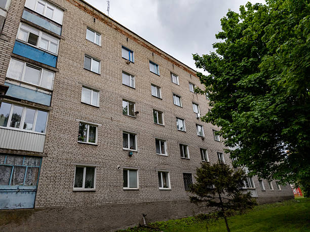 istock A tall brick building with many windows and a tree in front of it 2218129193