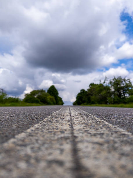 istock A long empty road with a cloudy sky in the background 2218129346