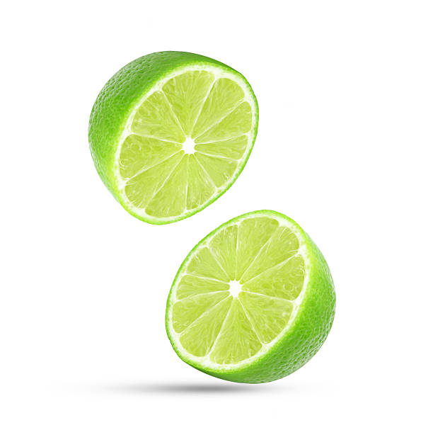istock Slices of lime falling in the air isolated on white 2218131013