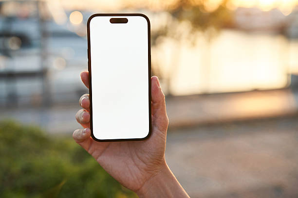 istock Young woman showing mobile phone blank white screen on Marina Background 2218131103
