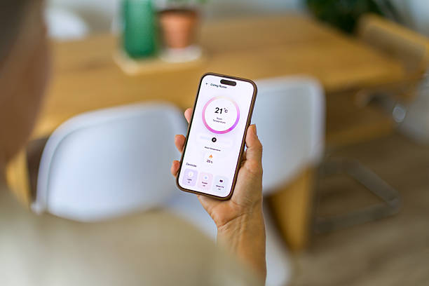istock Woman using smart home application on mobile phone to control temperature and lighting 2218131904