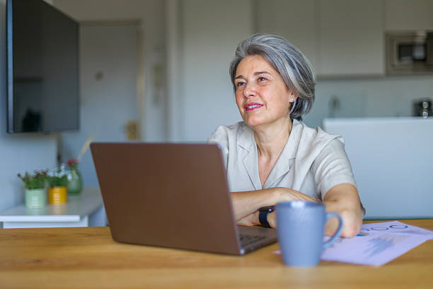 istock Senior businesswoman working from home using laptop and analyzing graphs 2218131951