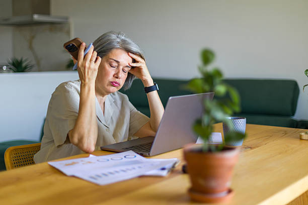 istock Stressed mature businesswoman having headache while working from home 2218131984