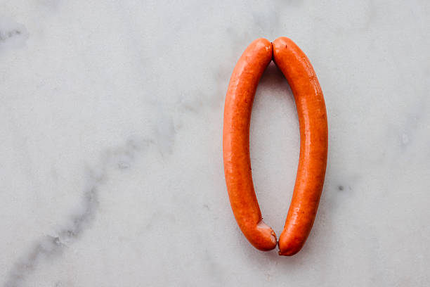 Two Frankfurters, or Wiener sausages on marble background.