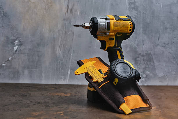 istock A tool belt holding a cordless drill, caliper, and tape measure lies on a worktable. Tools for construction and DIY projects. 2218134894
