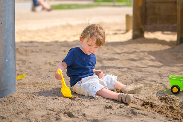 istock Toddler Playing Quietly In Sand 2218135096