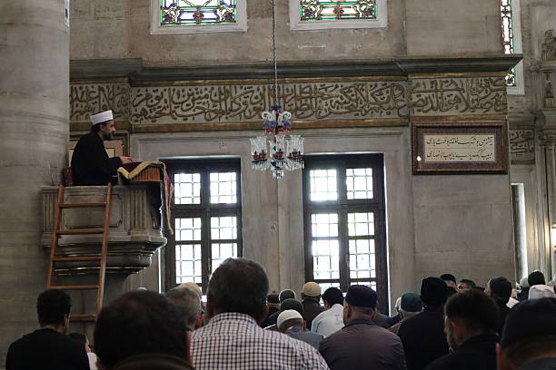 Istanbul, Turkey - April 26, 2025: Imam preaches to muslim congregation on pulpit in Eyup Sultan Mosque.