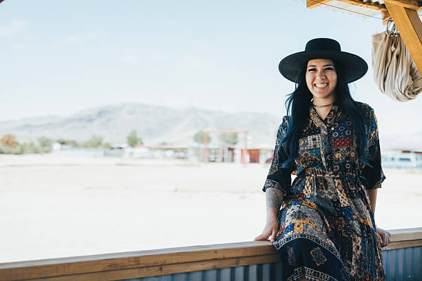 A portrait of a fashionable woman in the desert on a ranch.