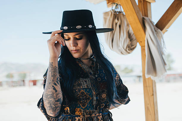 A portrait of a fashionable woman in the desert on a ranch.