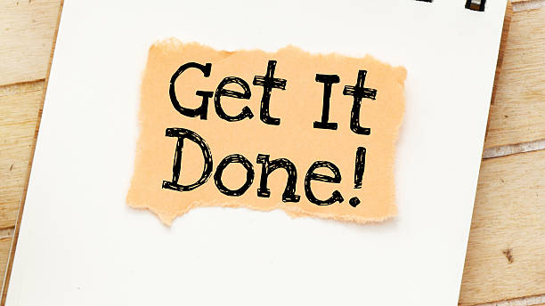 istock GET IT DONE words on a small piece of paper laid on an office notebook. 2218141214