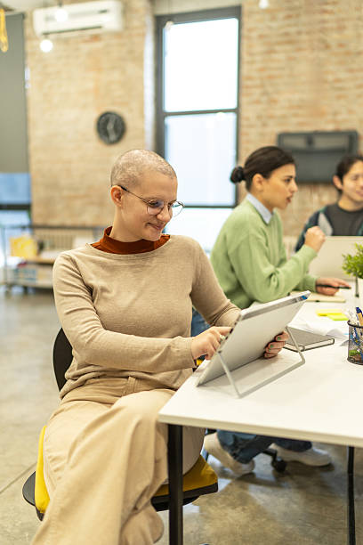 istock Young businesswoman with shaved head using digital tablet in modern office 2218141719