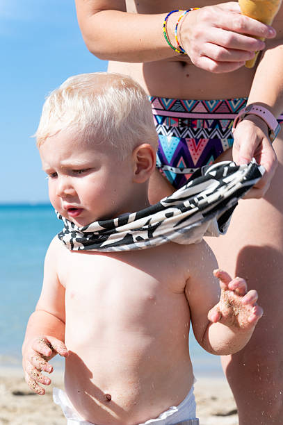istock Mother dressing her baby boy on a sunny beach 2218143039