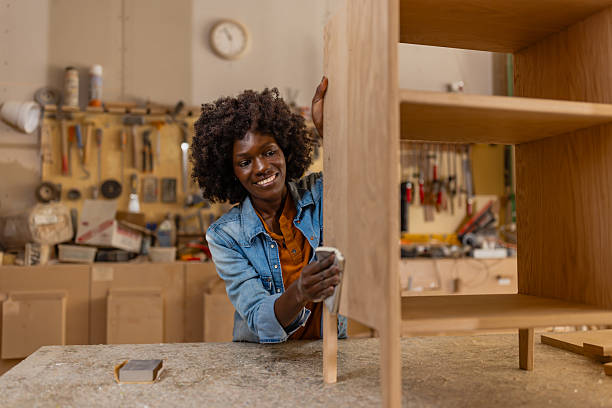 istock Smiling artisan sanding wood in creative workspace 2218145243