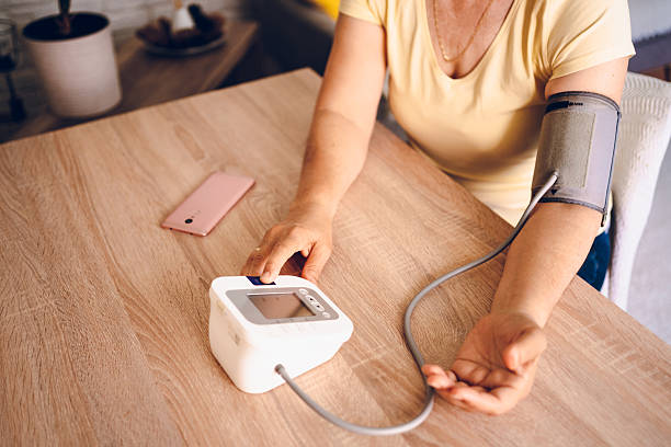 istock Woman check blood pressure measure device on hand 2218145436