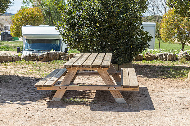 The Empty gray wooden table on the green plants background with motorhome