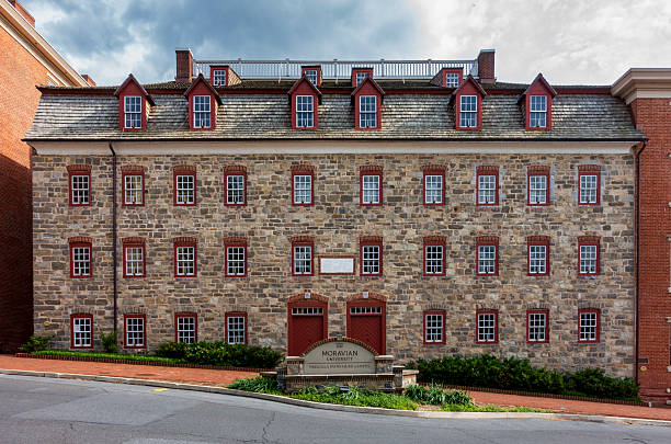 Bethlehem, PA - US - May 25, 2025 Brethren's House at Moravian University's Hurd Campus; historic stone structure with red-framed windows, gabled roof, and central entrance; echoes colonial roots.