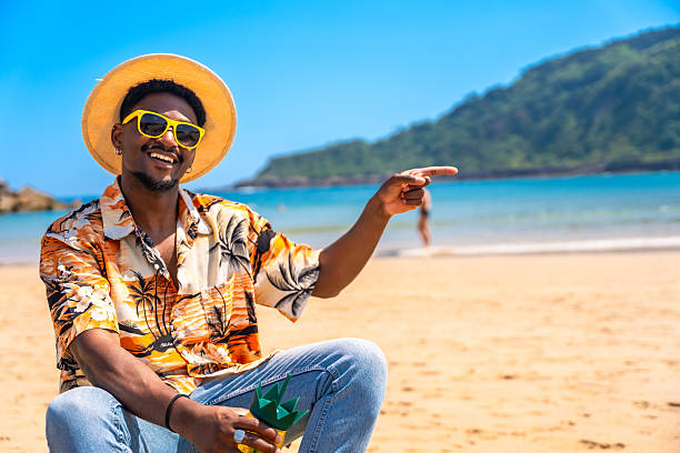 istock Young man pointing away while enjoying a tropical beach 2218150647