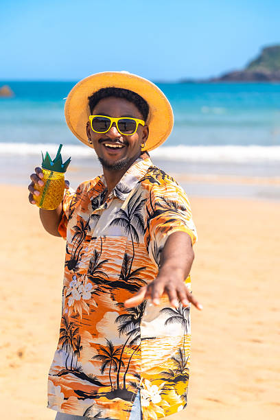 istock Young man enjoying a pineapple cocktail on a tropical beach 2218150648