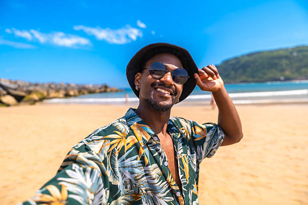 istock Young man taking a selfie on a sunny beach 2218150671