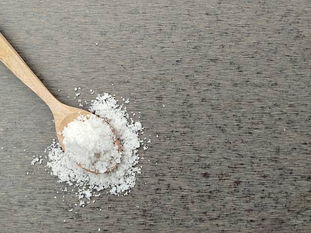 istock Salt on wooden spoon with grey background 2218153491