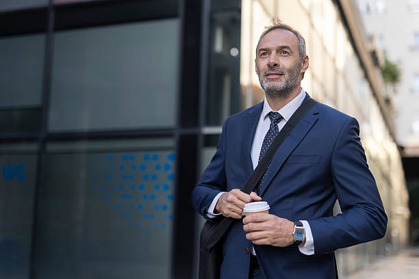 istock Businessman strolling with a drink in an urban backdrop 2218155282