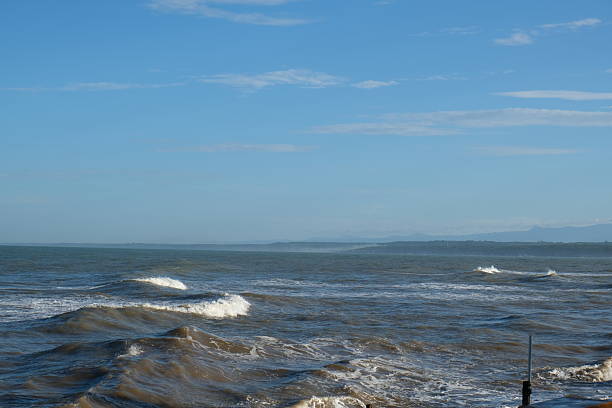 istock Serene view of a beach with gentle waves under a blue sky. 2218156994