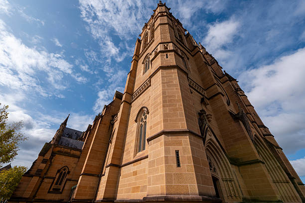 Top part of old church with cross on roof against clear blue sky background with copy space, silhouette, full frame horizontal composition