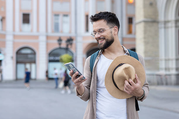 istock Man sending text on phone joyfully in bustling urban scene 2218159993