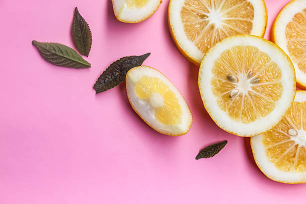 close up of lemon slices on pink background with negative space