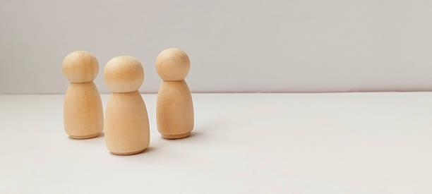 istock Wooden figurines standing together minimalist setting decorative art neutral background close-up view unity concept 2218169419