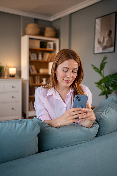 istock Woman relaxing on sofa using smartphone at home 2218171843