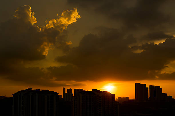 Golden sunset creating a dramatic silhouette of city buildings against a vibrant sky