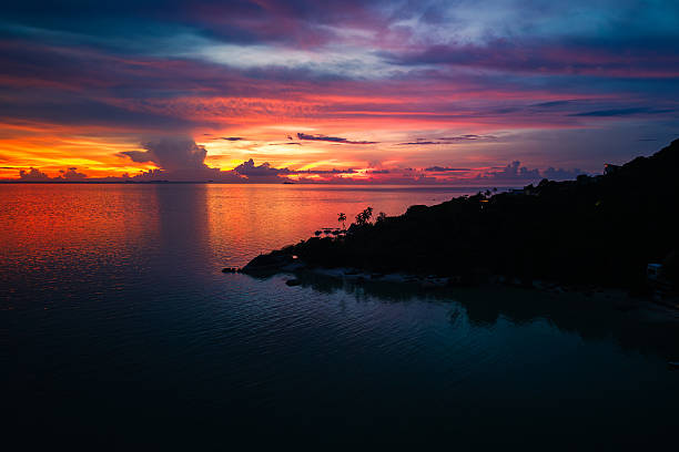 istock Sunset Over Ocean with Palm Silhouette 2218185427