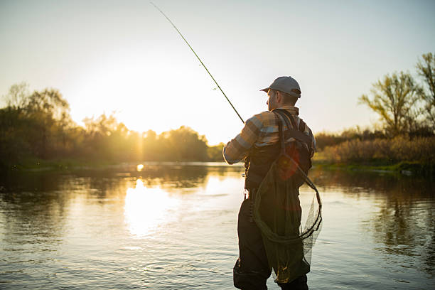 istock Fisherman casting fly line in river at golden hour. 2218187352