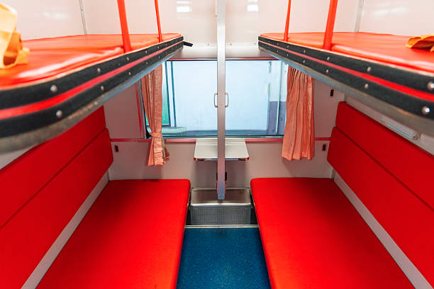 Sleeping compartment of a passenger train from the inside. Upper berth in the passenger interior of a sleeper compartment in a train.