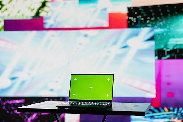 istock Empty space with a laptop showing green screen mockup next to artistic lights 2218192345