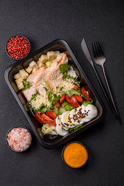 istock Bowl with caesar salad with chicken, parmesan cheese, tomatoes, croutons, lettuce leaves 2218192575