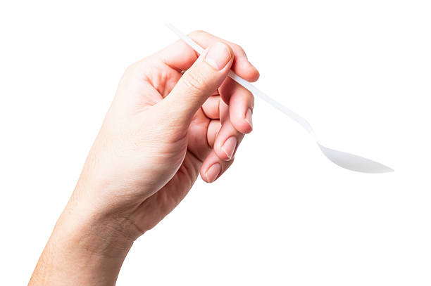 istock Male hand holding a white plastic spoon isolated on white background. 2218194740